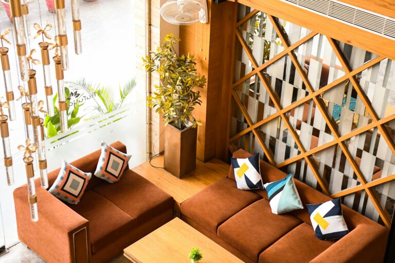 Stylish living room with brown sofas, decorative pillows, and modern decor in a cozy setting.